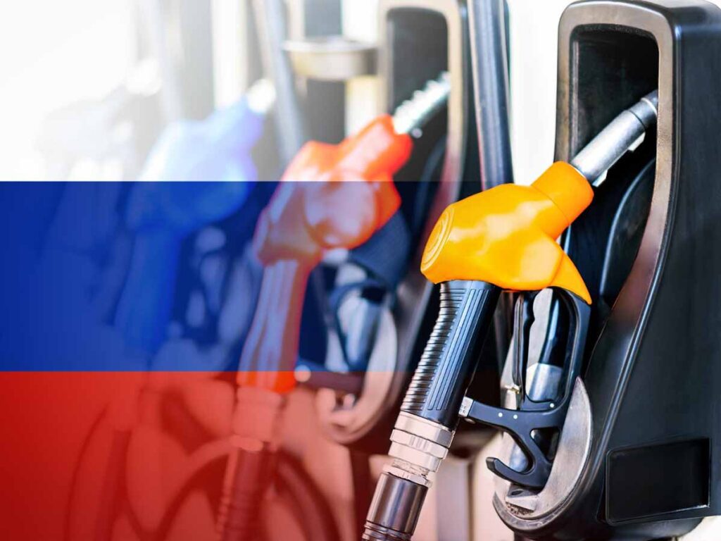 Топливные пистолеты на автозаправочной станции на фоне российского триколора.